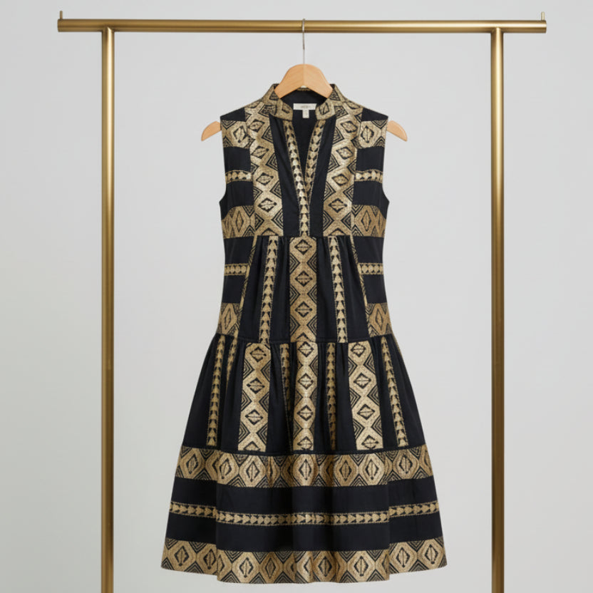Navy blue and gold Aztec geometric print sleeveless tiered babydoll mini dress with V-notch keyhole neckline, styled with gold jewelry and navy bag | The Pretty Pistol