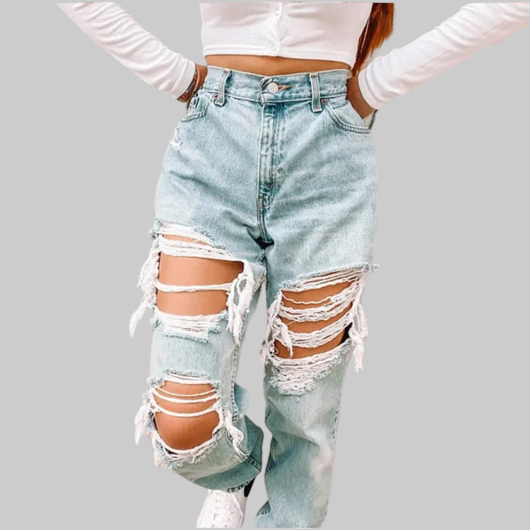High rise baggy light wash ripped jeans with massive blown-out distressing at both thighs and knees, worn with a white crop top and sneakers | The Pretty Pistol