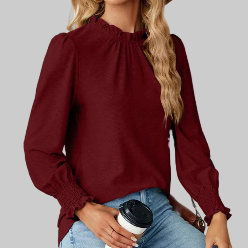 Wine red long-sleeve ruffle mock-neck blouse with smocked ruffle cuffs, styled with light wash jeans and a tan crossbody bag | The Pretty Pistol