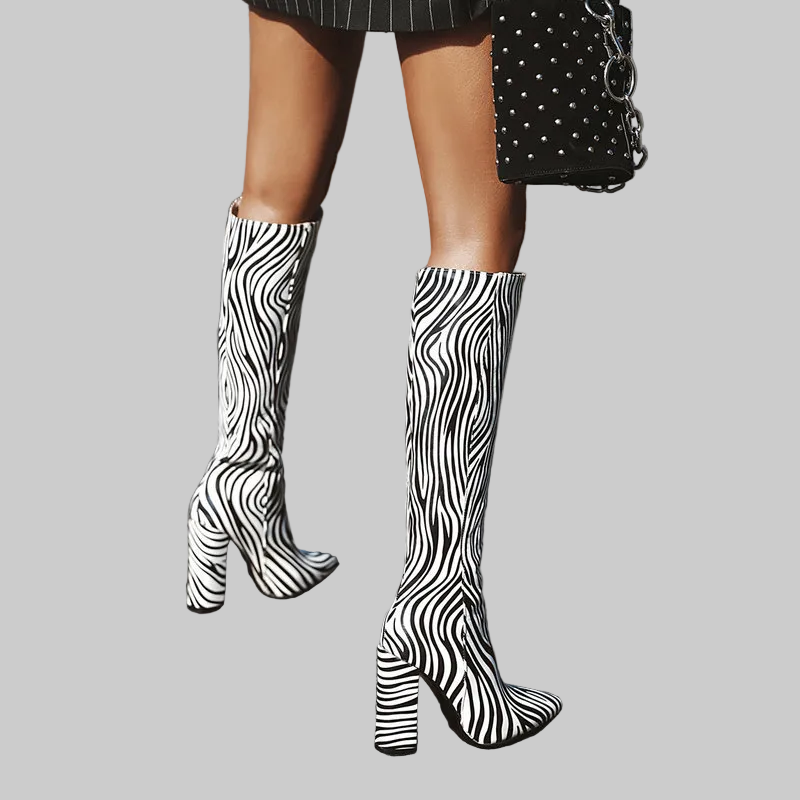 Black and white wavy zebra print high-shine knee-high boots with tall chunky block heel, pointed toe, and side zip closure | The Pretty Pistol