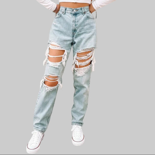 High rise baggy light wash ripped jeans with massive blown-out distressing at both thighs and knees, worn with a white crop top and sneakers | The Pretty Pistol