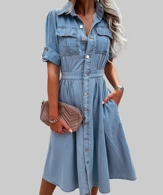 Light blue button-front denim shirt dress with pointed collar, elasticated waist, dual chest flap pockets, and flowy gathered A-line midi skirt | The Pretty Pistol