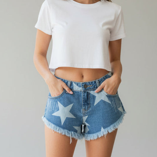 Medium wash denim shorts with large tonal bleached star print, mid-rise fit, and dramatic raw fringe hem | The Pretty Pistol