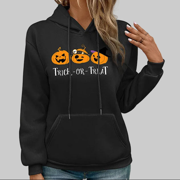 Black Trick-or-Treat pumpkin graphic hoodie with drawstring hood and front pocket, relaxed fit styled with jeans | The Pretty Pistol